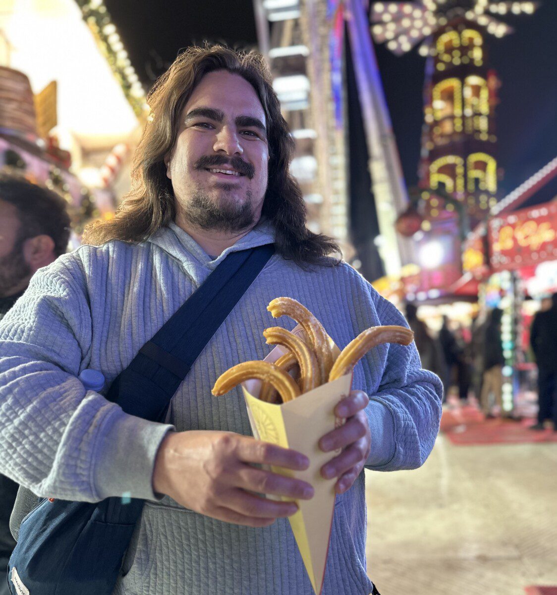 Dan holding churros at a street fair.